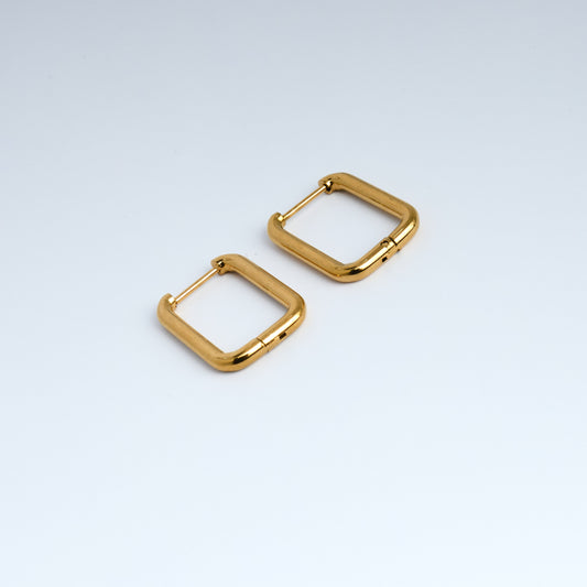Gold square hoop earrings on a light gray background