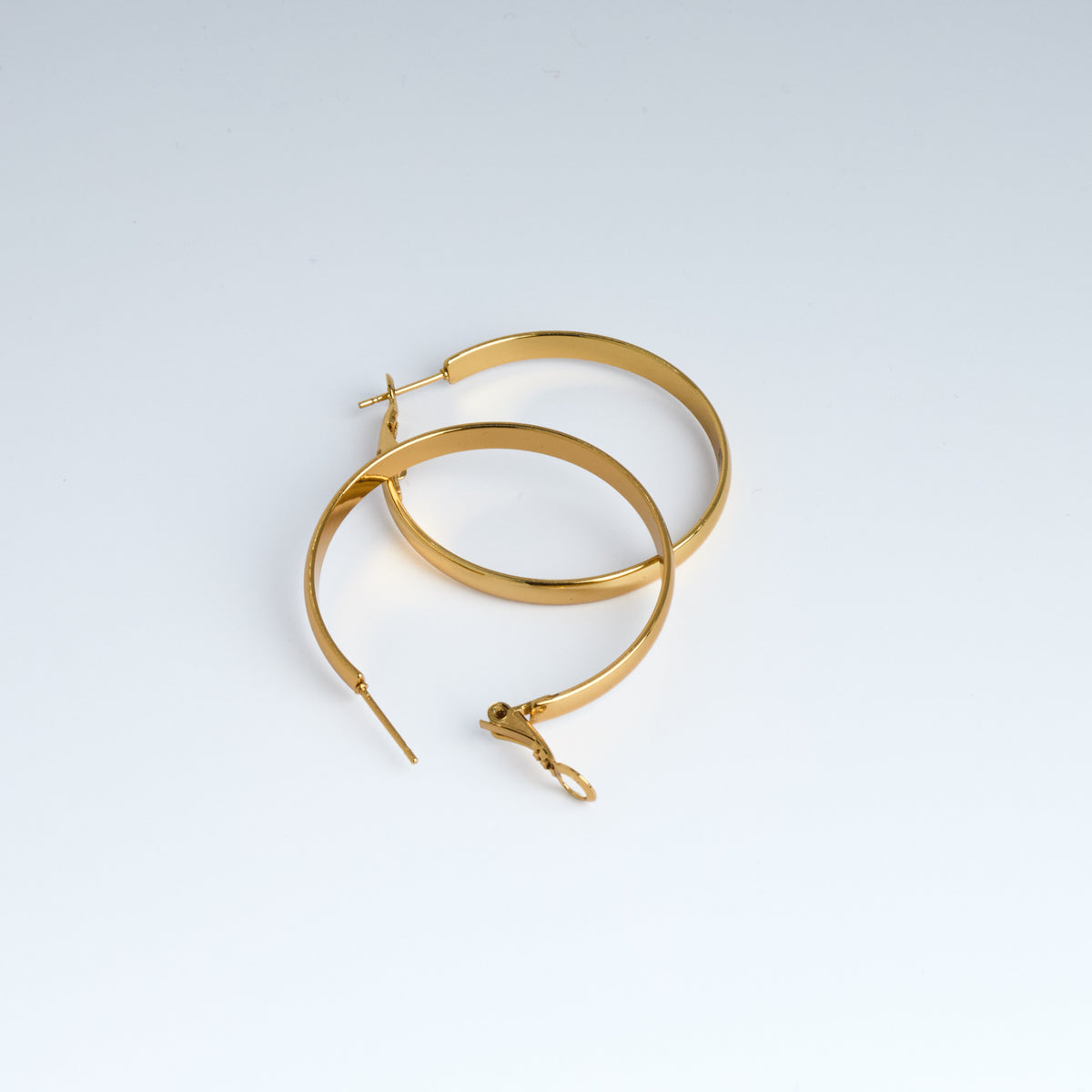 Gold hoop earrings on a light gray background