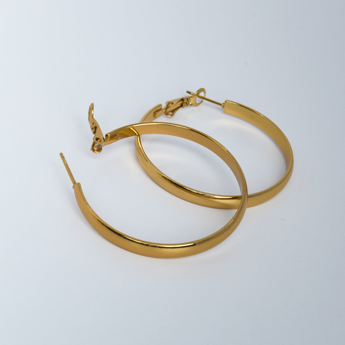 Gold hoop earrings on a light gray background