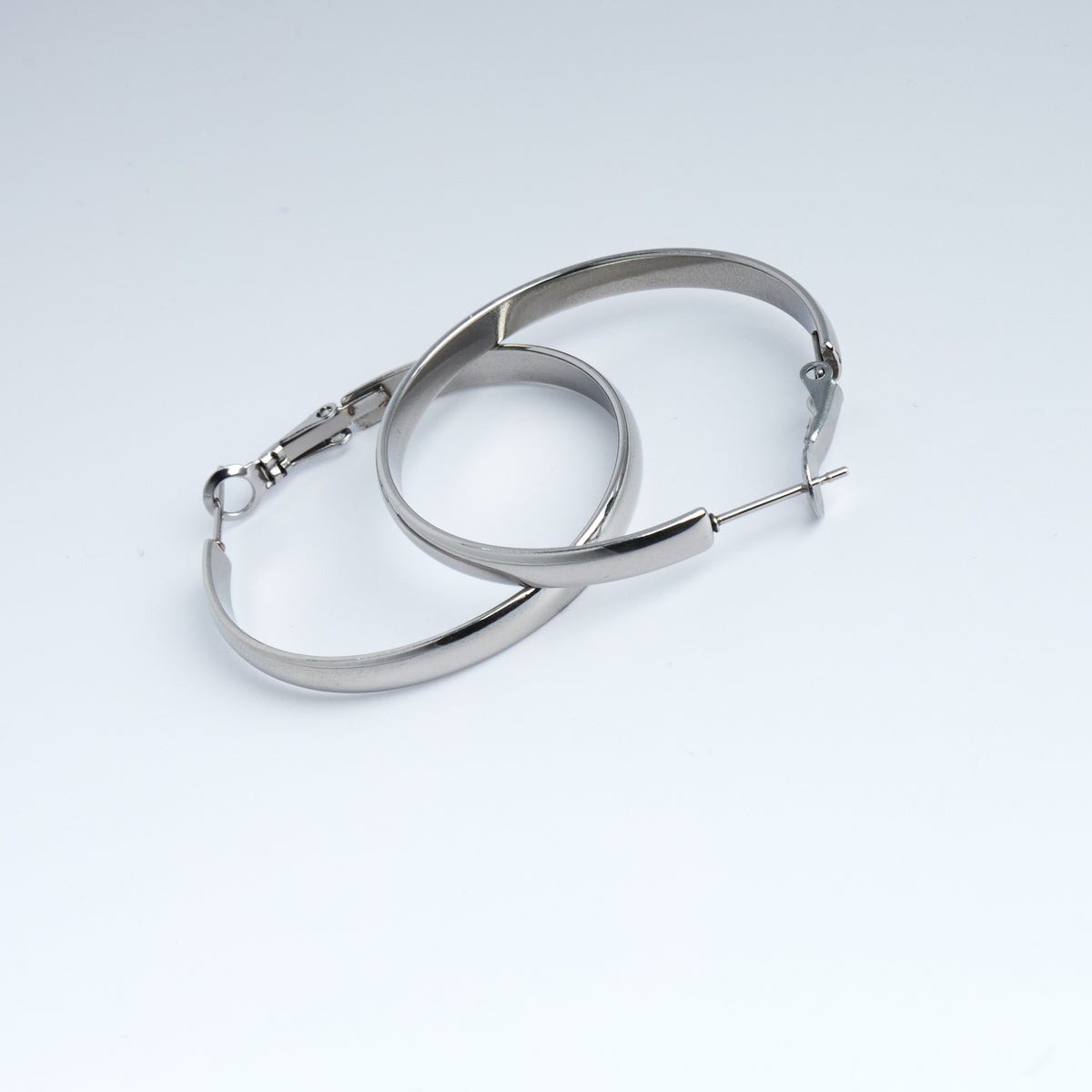 Pair of silver hoop earrings on a light gray background
