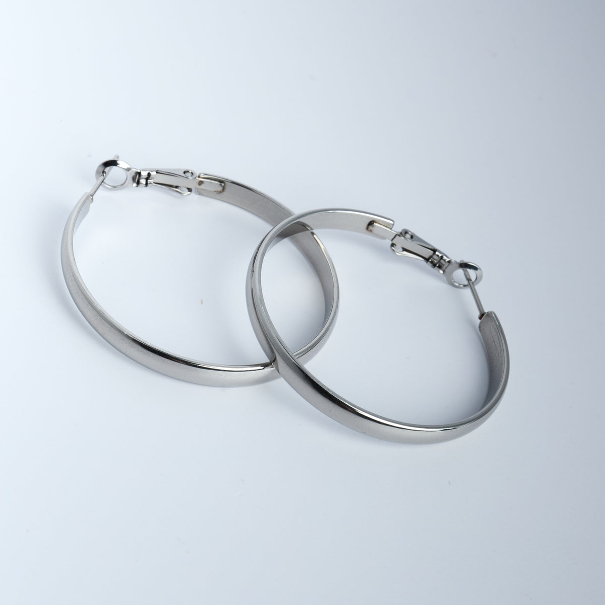 Pair of silver hoop earrings on a light gray background