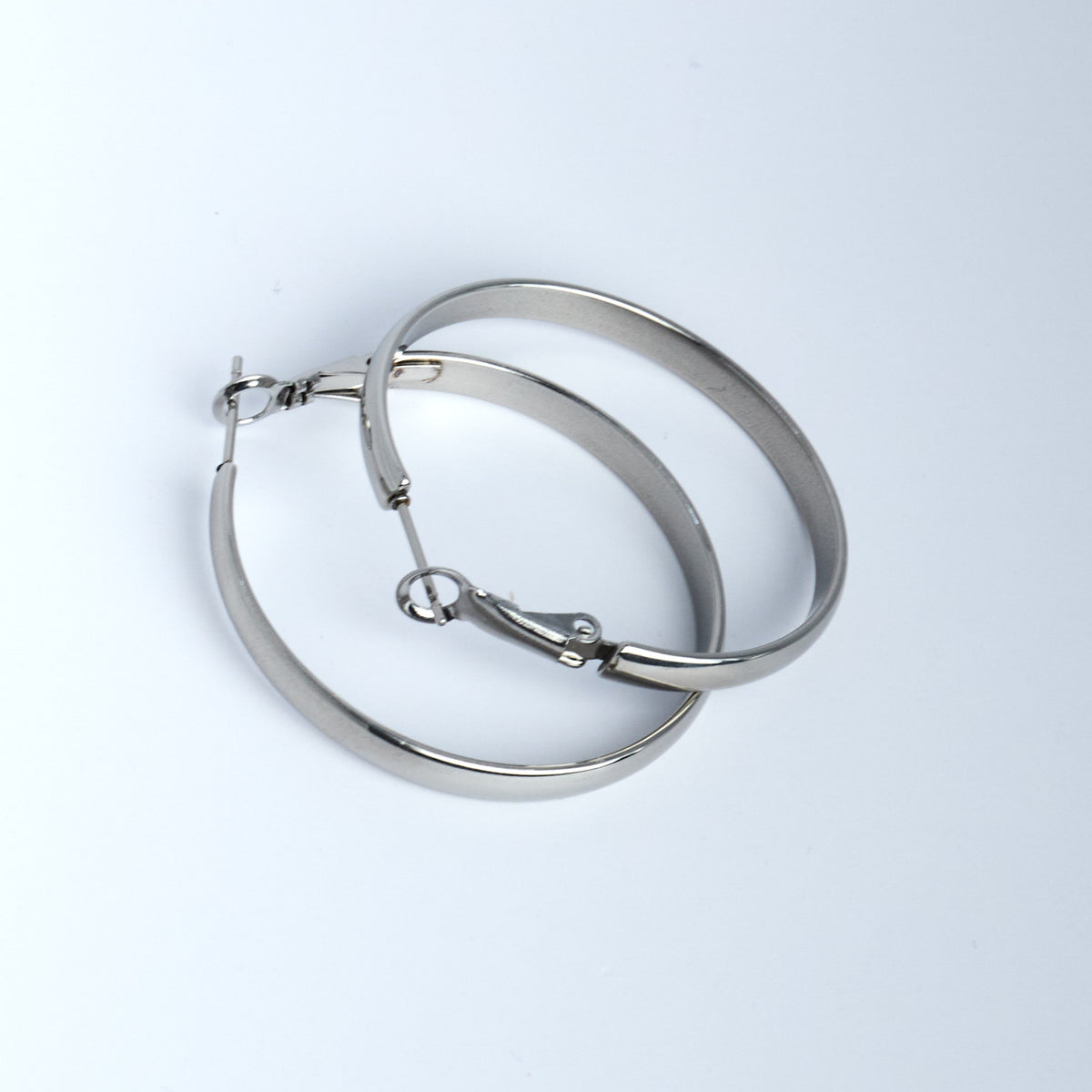 Pair of silver hoop earrings on a light gray background
