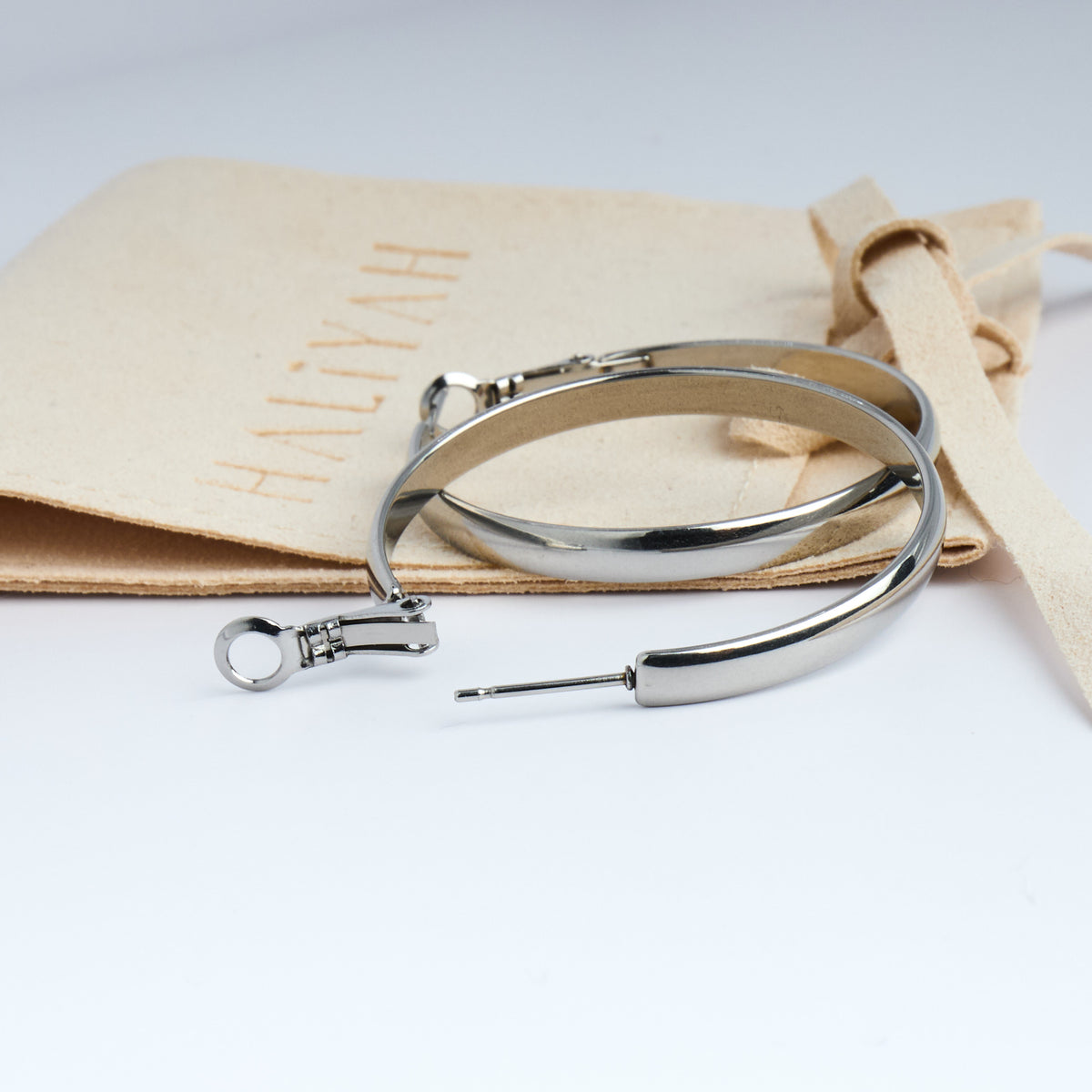Metal clasp on a white background with beige fabric